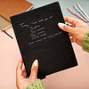 Black notebook with etched handwritten message