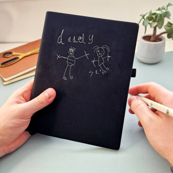 Black notebook with childs handwriting and drawing