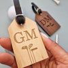 Luggage tag with the initials GM etched on the front